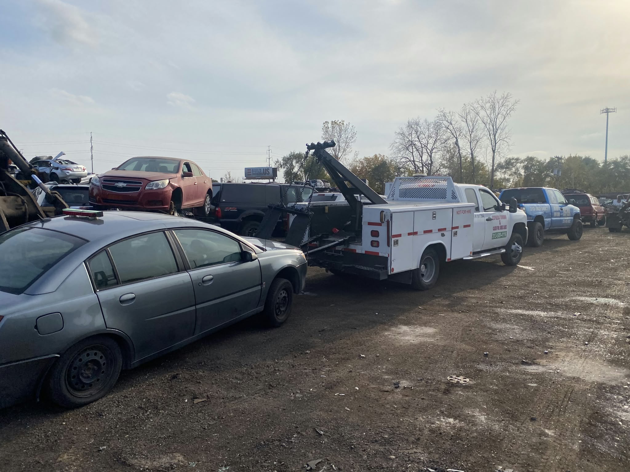 Express Towing truck among vehicles at a salvage yard